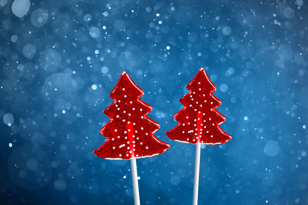 圣诞树红甜甜的糖果，雪花散科蓝色的背景图片下载