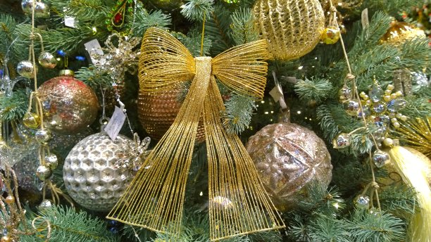 圣诞树装饰品:金色的丝带蝴蝶结，闪亮的小玩意，球。收藏圣诞佳节的魔术展览。新年快乐。家庭、咖啡馆和办公室的装饰。为假期设计室内。图片下载