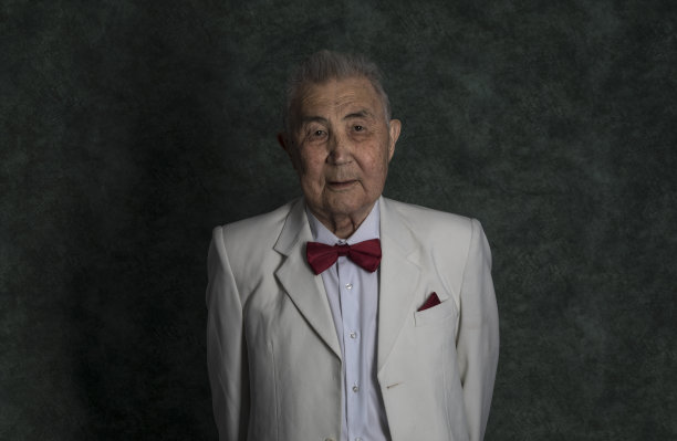 在一个工作室的背景上，一个穿着白色西装的老人的黑色肖像图片下载