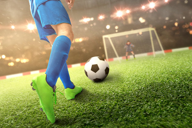 足球运动员在足球场上踢球的后视图图片下载