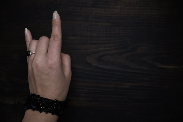 两根手指向上的手势。女性的手是一只山羊，是岩石的象征。图片下载