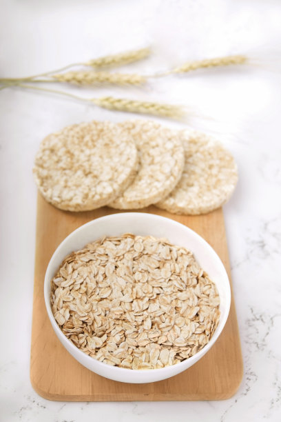早餐燕麦片放在木板上，旁边是脆面包，背景是白色的图片下载