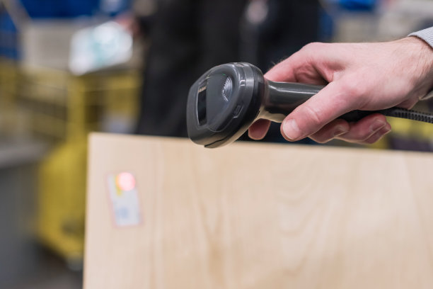 在超市购物时，顾客用手扫码器扫描打折卡。自我满足图片下载