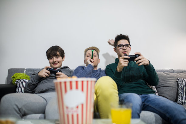 幸福的家庭。妈妈和孩子们在玩电子游戏图片下载