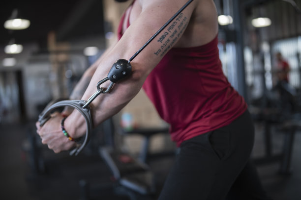 专注于男性在健身房使用有线健身器材图片下载