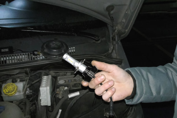 电工手中的氙气灯。更换氙气灯。图片下载