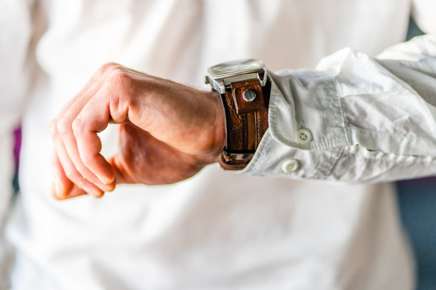 近距离观察穿着白衬衫的男人，看他的腕表计时图片下载