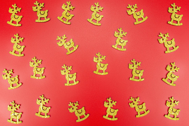 背景由金色的驯鹿随机安排在红色的背景上。图片下载