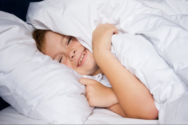 小男孩躺在卧室里微笑图片下载