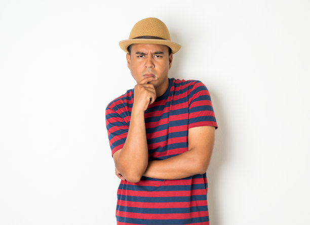 27-35岁左右的亚洲男人正在思考，做着鬼脸，困惑，不理解，对一些事情感到疑惑。这张照片是在照相馆拍的。白色背景图片下载