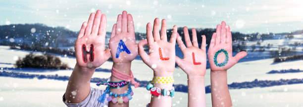 孩子们的手建立单词Hallo的意思是你好，下雪的冬天背景图片下载