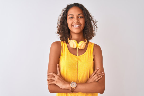 年轻的巴西女子戴着黄色耳机在孤立的白色背景下快乐的脸微笑着，双臂交叉看着镜头。积极的人。图片下载