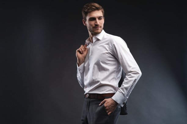 一个英俊的年轻商人的肖像穿着西装孤立在灰色的背景。图片下载