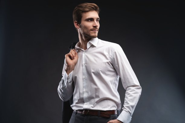 一个英俊的年轻商人的肖像穿着西装孤立在灰色的背景。图片下载