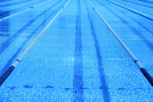 带有比赛跑道的奥运经典蓝色游泳池。2020年流行色蓝色背景。图片下载