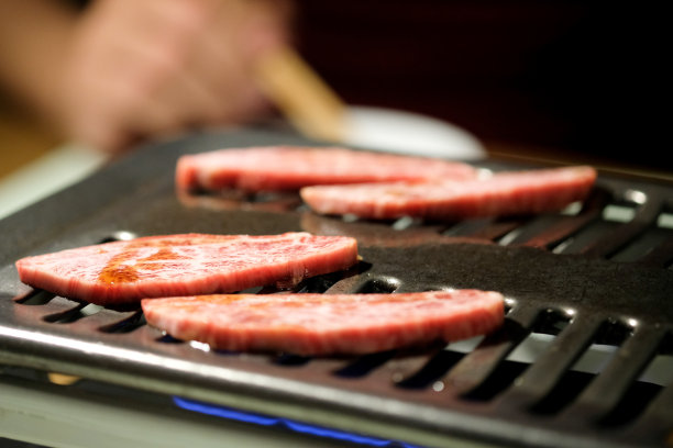 在日本北海道烧烤炉上烹饪的优质牛肉片图片下载