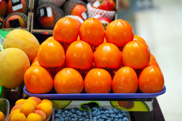 微距拍摄柿子果实。柿子商店关门了。鲜橙柿子。水果的背景。健康饮食。收获的柿子特写。杂货店市场上的水果图片下载