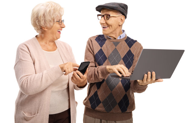 老年人使用现代科技，一台笔记本电脑和一部智能手机图片下载