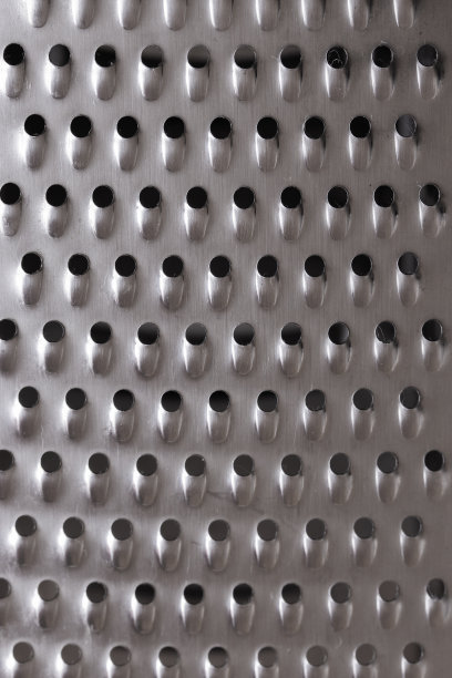 纹理金属银色的表面带有小孔，不锈钢的蔬菜刨丝器特写。背景背景纹理效果图片下载