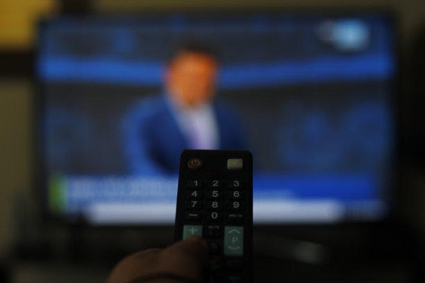 有电视遥控器的人可以通过遥控器切换频道来观看电视节目。图片下载