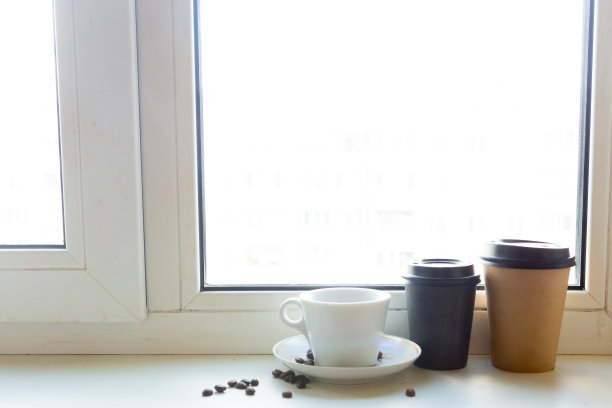 咖啡杯和可以带走的咖啡放在窗台上图片下载