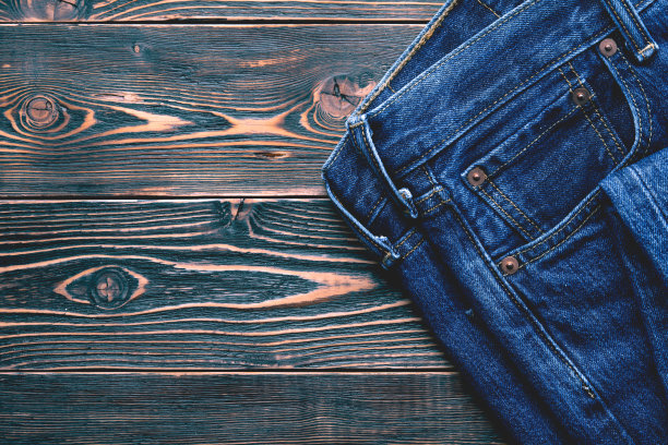 旧木头背景上的牛仔裤图片下载