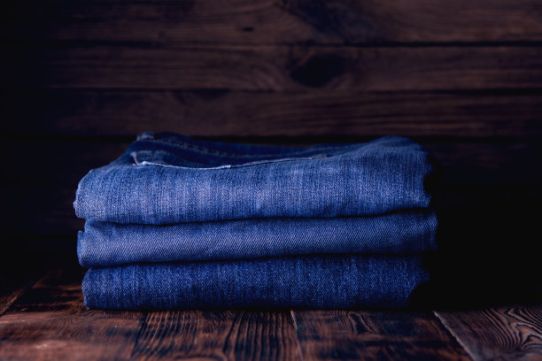 木制背景上的牛仔裤堆叠图片下载