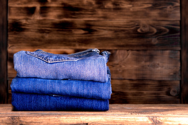 木制背景上的牛仔裤堆叠图片下载