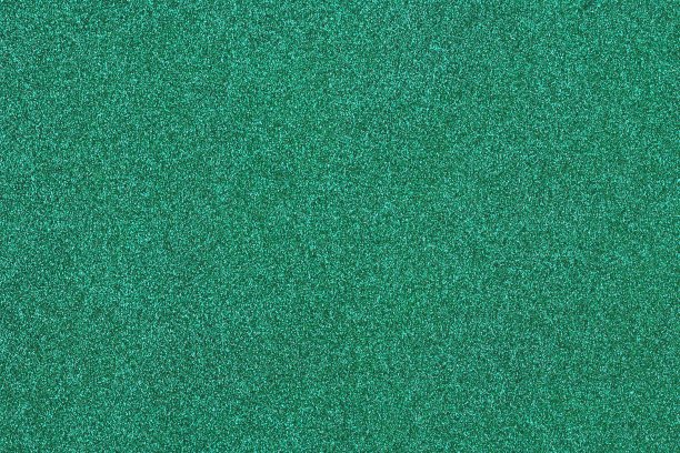 背景绿色闪亮的辉光充满了闪亮的金色闪光。图片下载