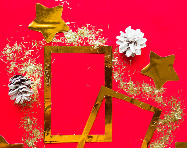 圣诞快乐，恭贺新禧。平躺照片与金色模型相框和圣诞装饰在明亮的红色背景。圣诞贺卡，横幅。为文本复制空间图片下载