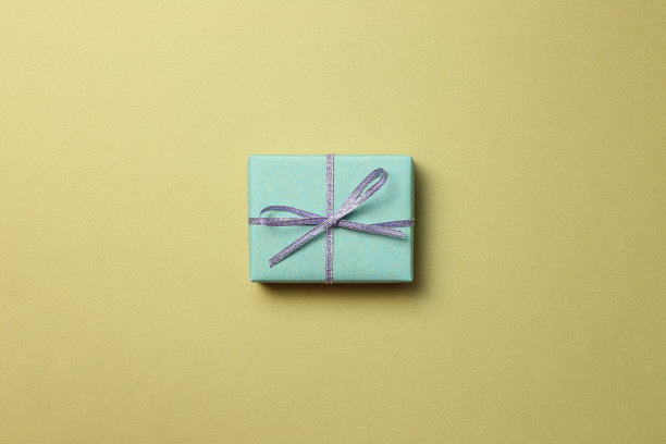 绿色的礼品盒在卡其背景。圣诞节或生日、周年纪念概念图片下载