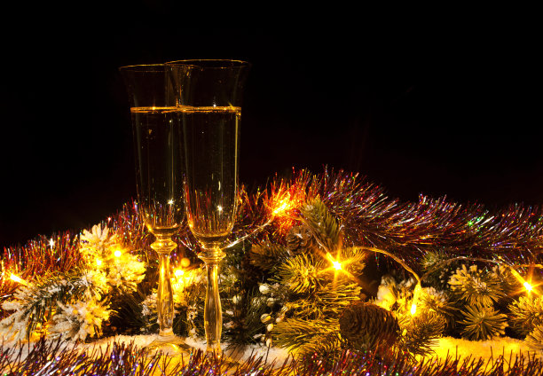 香槟杯放在有冷杉树枝和花环的雪地上图片下载