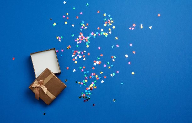 在蓝色背景上打开方形的空礼品盒，靠近多色亮片图片下载