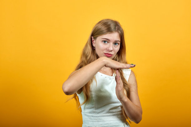 可怜的金发白种年轻女子看着镜头做着打手势图片下载