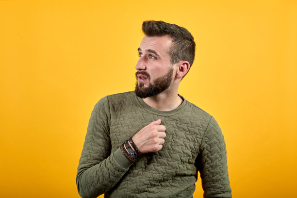 开朗英俊的白人男子看向一边，手放在胸前图片下载