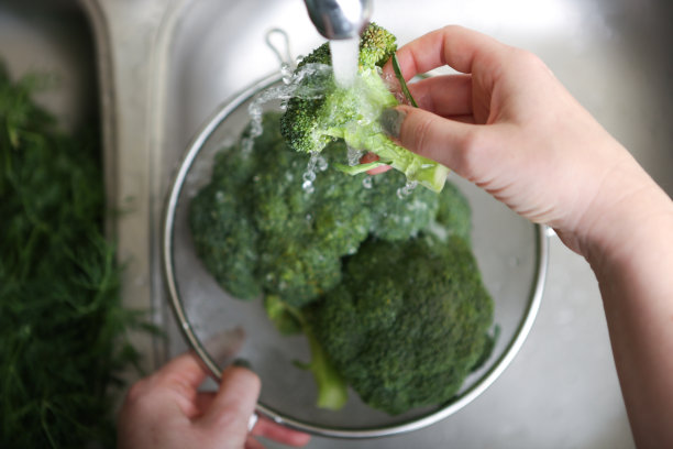 在厨房水槽里洗花椰菜的女人图片下载