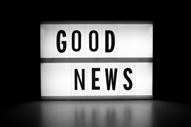 好消息-在黑暗中发光显示器上的文字。图片下载