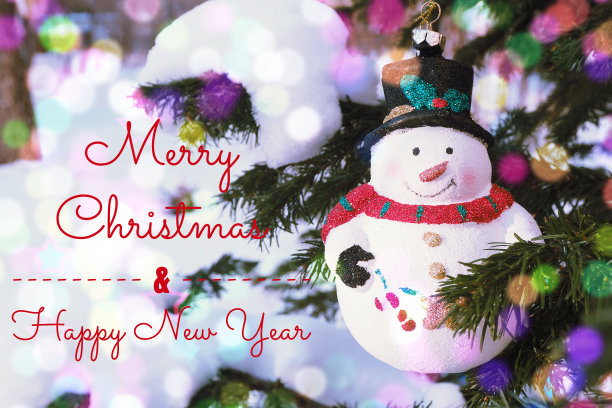 上面写着“圣诞快乐，新年快乐”的贺卡。圣诞树玩具雪人戴着红色的围巾和黑色的帽子在圣诞树上。图片下载