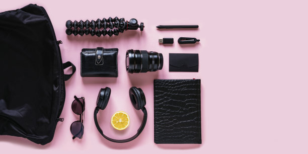 现代黑色配件，小玩意和柠檬片在粉红色的背景，俯视图图片下载