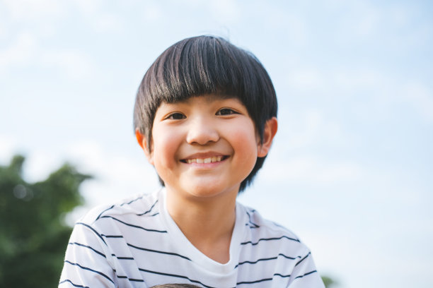 快乐可爱的亚洲男孩的微笑肖像，在阳光灿烂的日子在公园放松，家庭或成功的养育。——图片图片下载