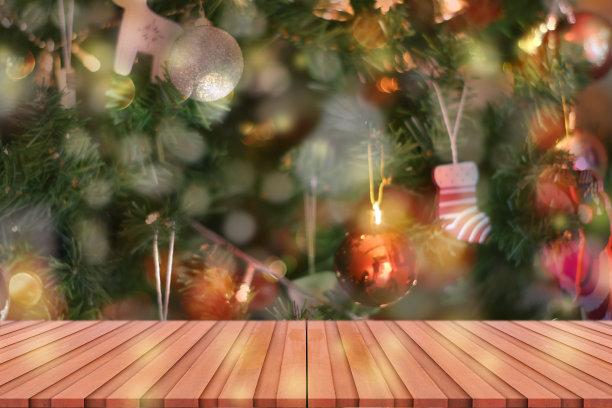 木质桌面上模糊的彩色圣诞树和散景背景，用于展示或蒙太奇产品。图片下载