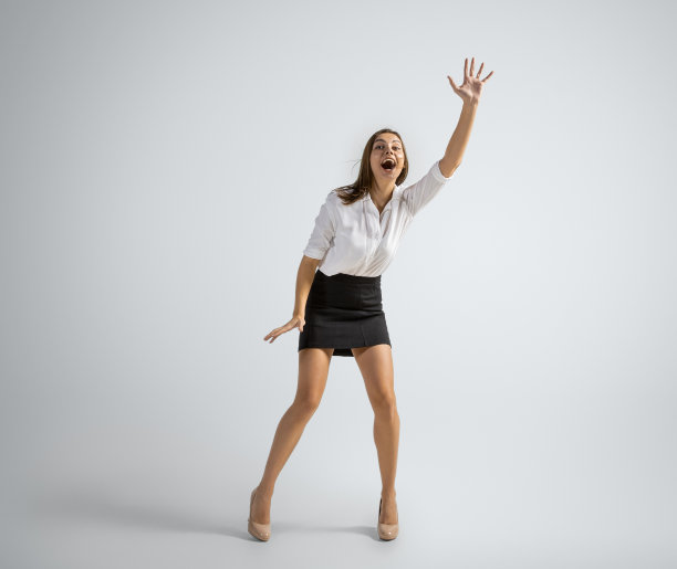 白人妇女在办公室的衣服接球孤立在灰色的工作室背景图片下载