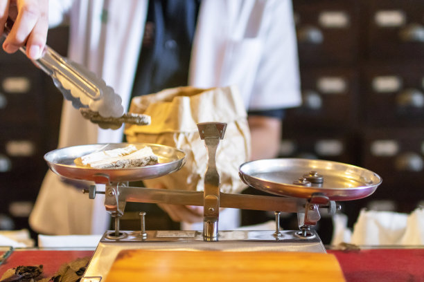 医生的传统药物重量，干燥的药草在vintage平衡秤在老药铺。图片下载