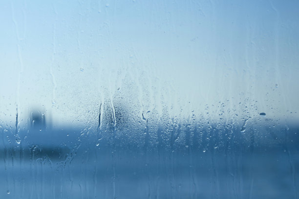 蓝色的窗玻璃有水滴和模糊图片下载