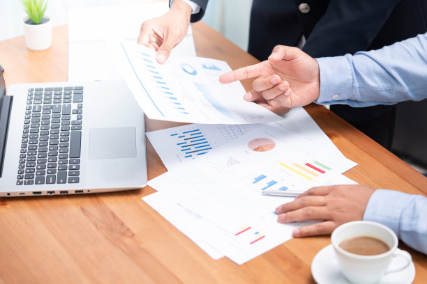 两个商人的手正在处理商业报告。图片下载
