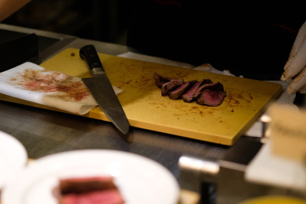 在豪华的晚宴上，近距离的牛排片和刀放在木板上图片下载