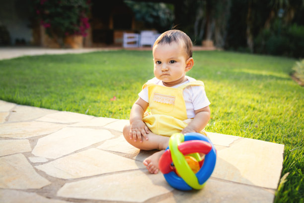 可爱的小女孩，坐在后院的地板上玩耍图片下载