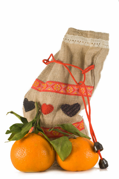 两个橘子，一根绿树枝。在一个白色背景的特写。礼品袋。图片下载