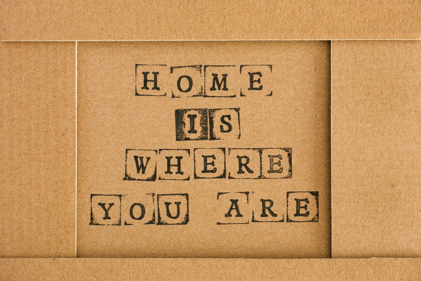 印有“家就是你的家”字样的硬纸板由黑色字母邮票制成。图片下载