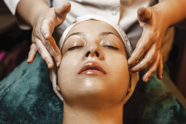 一个可爱的白人女人有皮肤护理常规在一个健康水疗中心的特写。图片下载